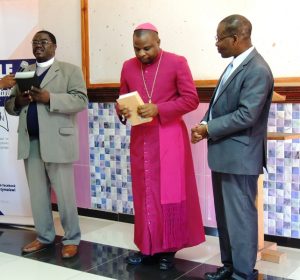 Rev Dr L Nyondo and Bishop Magangani receiving the Bibles on behalf of the church from Mr Clapperton Mayuni, BSM Executive Director